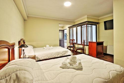 波托西帕特里莫尼奥-波托西旅馆的一间卧室配有两张带毛巾的床