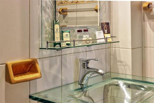 波托西帕特里莫尼奥-波托西旅馆的浴室水槽设有玻璃台面和镜子