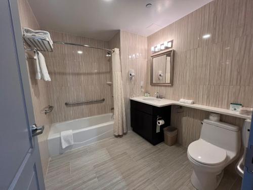 皇后区纽约瑞景酒店的浴室配有卫生间、盥洗盆和淋浴。