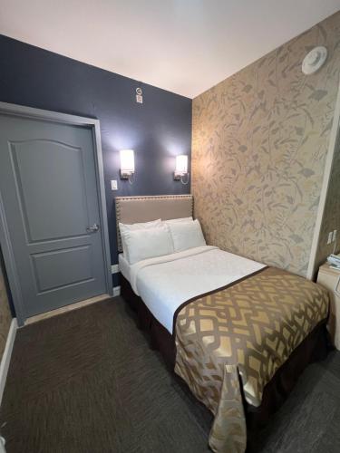 皇后区纽约瑞景酒店的小型酒店客房,设有床和墙壁