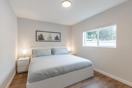 西雅图Beautifully remodeled Rambler in South Seattle的白色的卧室设有床和窗户
