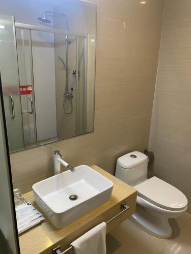 江门江门绿岛假日酒店的一间带水槽、卫生间和镜子的浴室
