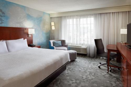 渥太华渥太华市区万怡酒店的酒店客房,配有一张床、一张桌子和椅子