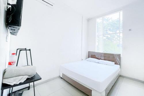 贝克西Citara Jaya Guesthouse Mitra RedDoorz的白色的客房设有床和窗户。