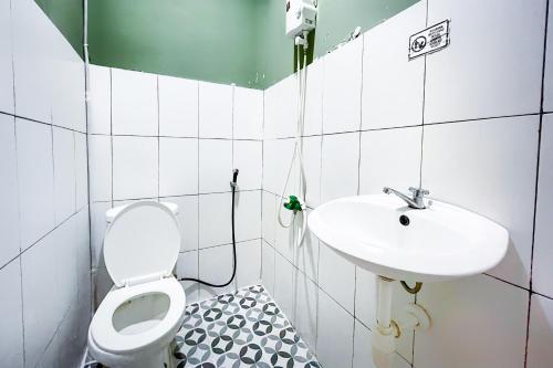 贝克西Citara Jaya Guesthouse Mitra RedDoorz的一间带卫生间和水槽的浴室