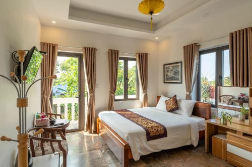 会安Rice River Villa - Hoi An的一间卧室设有一张床和一个阳台