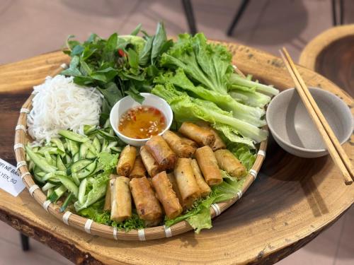 胡志明市Home Tea An Yên Dorm的桌上的盘子,配面条和蔬菜