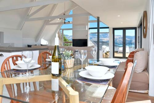阿卡罗阿Akaroa Harbour View - Christchurch Holiday Homes的用餐室配有玻璃桌和酒杯