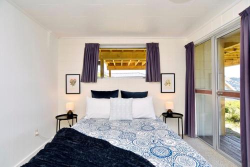 阿卡罗阿Akaroa Harbour View - Christchurch Holiday Homes的一间卧室,配有带2个床头柜的床