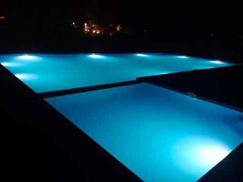 DhanwārVan Vihar Resort的夜间拥有蓝色灯光的游泳池
