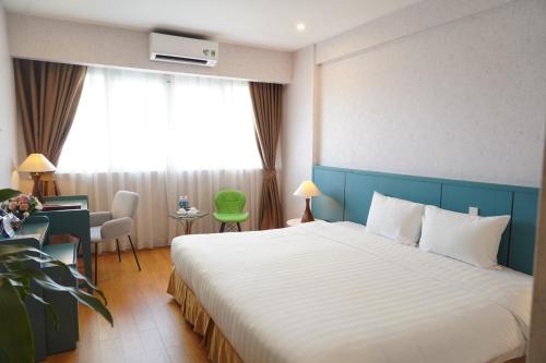 河内宝松国际酒店的酒店客房设有一张大床和一张书桌。