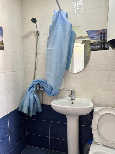 比什凯克HOLIDAY HOTEL的浴室设有水槽和蓝色的浴帘