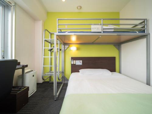 市川市Super Hotel Tozai line Ichikawa Myoden Ekimae的一间卧室配有两张双层床和一张书桌