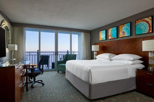 迈尔斯堡Marriott Sanibel Harbour Resort & Spa的酒店客房设有一张床、一张书桌和一个阳台。