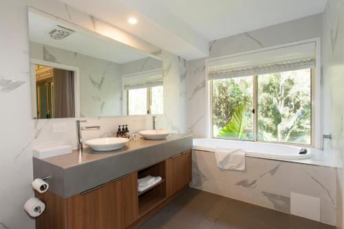 谭伯连山Songbirds Rainforest Retreat的一间带两个盥洗盆和大镜子的浴室