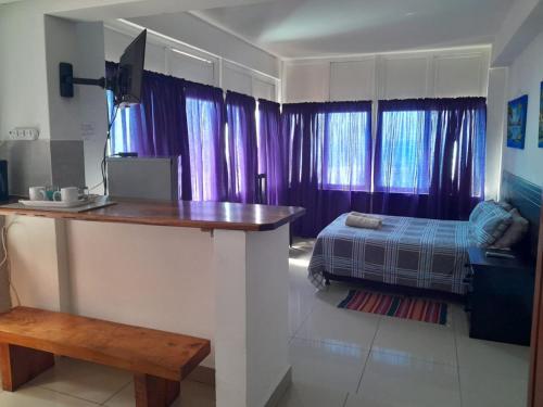 乌姆科马斯Umkomaas Lodge的紫色窗帘和床的房间