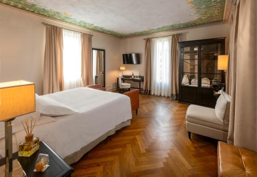 科斯蒂廖莱达斯蒂Villa Pattono Relais的一间卧室配有一张床、一张桌子和一把椅子