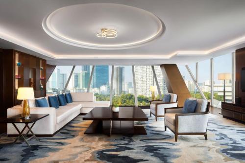 河内河内JW万豪酒店的带沙发和椅子的客厅以及大窗户。