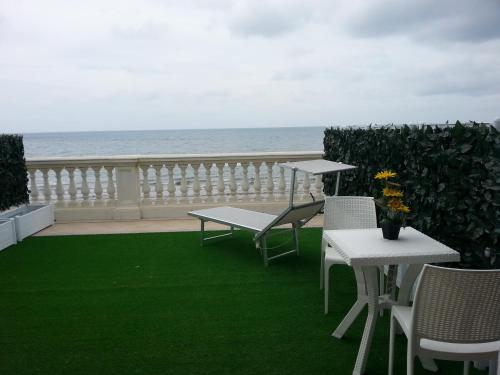 Giannella伊尔丽都酒店的一个带桌椅的庭院和大海