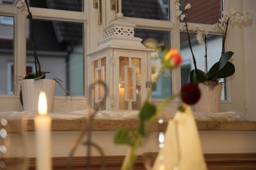 明德尔海姆Hotel und Gasthof Zur Laute的窗前的蜡烛和鲜花