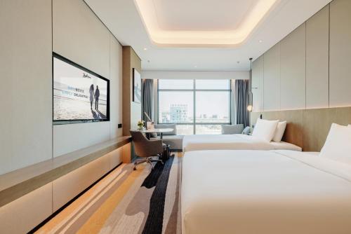 北京北京大兴机场丽筠酒店的一间酒店客房,设有两张床和电视