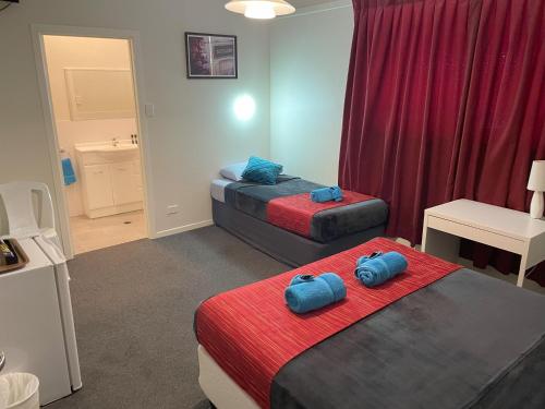 温顿北格雷戈里酒店的客房设有两张带蓝色枕头的床。