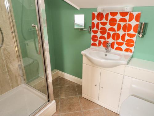哈佛威斯特The Annexe, Meadow Croft的浴室的墙壁上装饰有橙色和白色的图案
