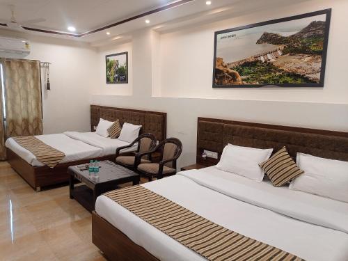 SheoganjSun Stone Hotel & Club - Jawai的酒店客房设有两张床和一张桌子。