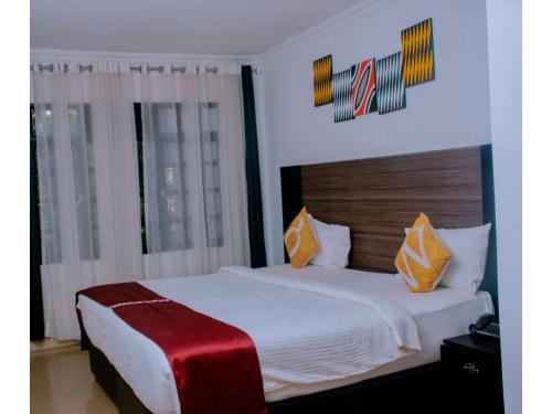基加利Boutique Hotel Rwanda的卧室配有一张带红色毯子的白色床