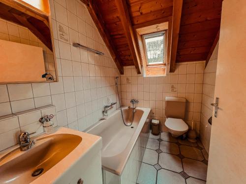 克洛滕Dachwohnung in Flughafennähe的一间带水槽、浴缸和卫生间的浴室