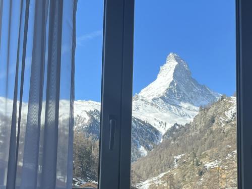 采尔马特布里斯都酒店的透过窗户可欣赏到雪山的景色