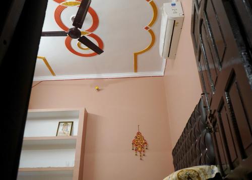 AyodhyaMalti Home stay 5 minute walking distance fromAyodhya DhamRailway Station的一间天花板的房间,墙上挂着一个钟