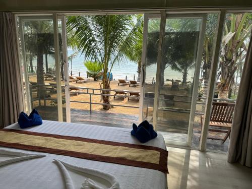 瓜隆岛Naroth Beach Bungalow的一间卧室配有一张床,享有海滩美景