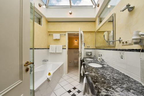 宾茨宾兹大酒店的带浴缸、水槽和镜子的浴室