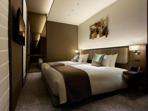 东京银座赛莱斯廷酒店的酒店客房配有一张带绿色枕头的大床