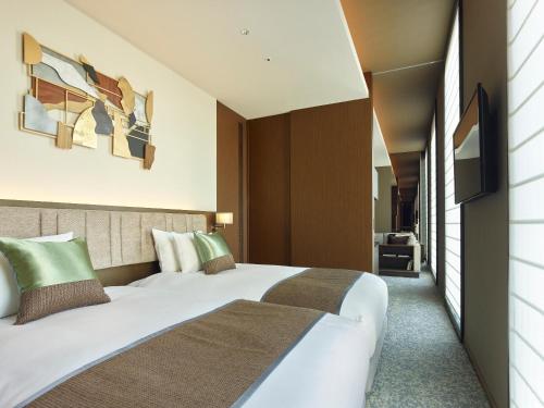东京银座赛莱斯廷酒店的酒店客房,配有床和电视