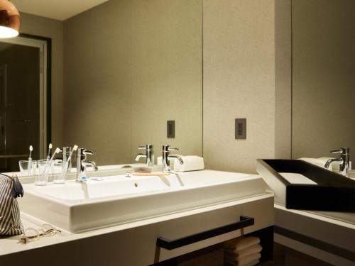 札幌Mitsui Garden Hotel Sapporo West的一间带两个盥洗盆和大镜子的浴室