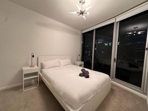悉尼Cozy 2 Bedroom Apartment Darling Harbour的白色的卧室设有床和大窗户