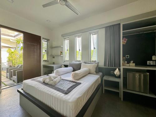 圣吉吉Villa Rumah Putih Abu Abu的一间卧室配有一张带白色床单的大床