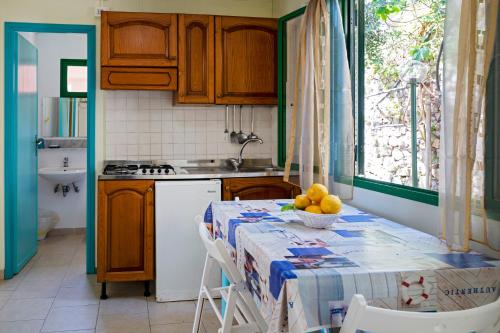 纳拉诺Camping Villaggio Nettuno的厨房配有一张桌子,上面放着一碗水果