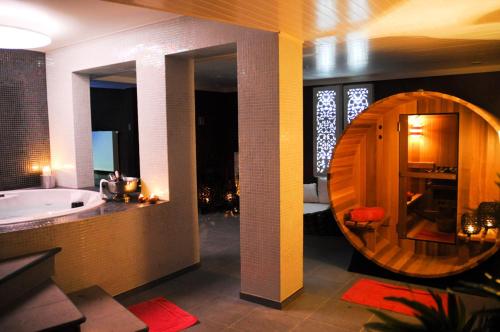绍德方丹Le Clos des Thermes Suites de Luxe avec wellness privatif的一间带浴缸和大镜子的浴室