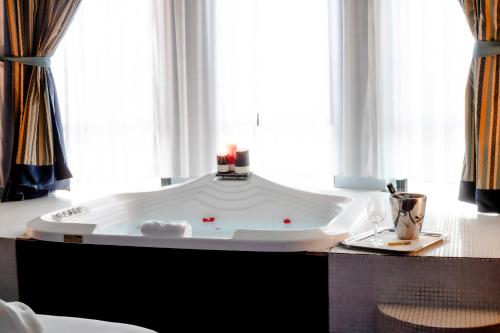 特尔尼Hotel Michelangelo Palace & SPA的窗户客房内的大浴缸