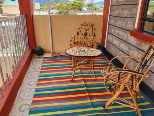 IsioloHotfoot Homestays的地毯上设有带两把椅子和一张桌子的庭院
