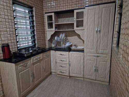 库马西Sigma Theta Homes - Kumasi Atimatim的厨房配有木制橱柜和台面