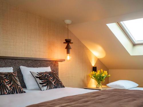 圣马洛圣马洛海滨美居酒店的一间卧室配有一张床和天窗