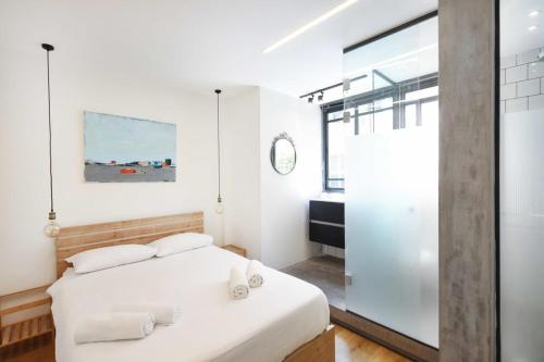 特拉维夫Design 2BR in Dizengoff st by HolyGuest的卧室配有白色的床和镜子