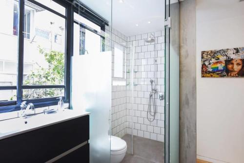 特拉维夫Design 2BR in Dizengoff st by HolyGuest的带淋浴、盥洗盆和卫生间的浴室