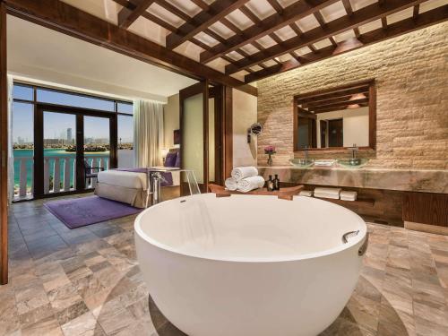 迪拜迪拜棕榈岛索菲特Spa度假酒店的带浴缸的大浴室和卧室