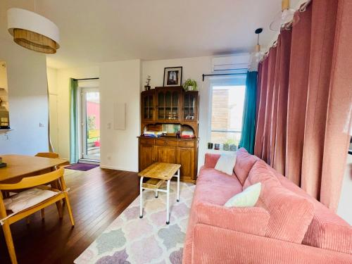 里尔Appartement Lille centre的客厅配有粉红色的沙发和桌子
