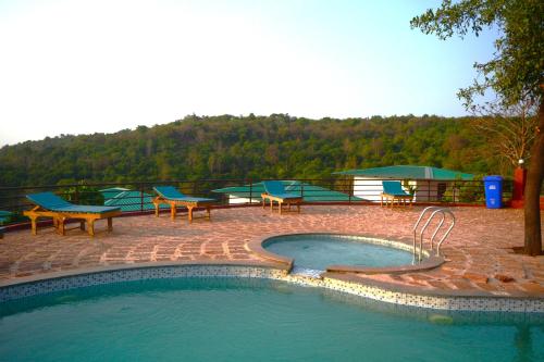 阿姆波尔Cashew leaf resort的游泳池周围设有桌子和长凳